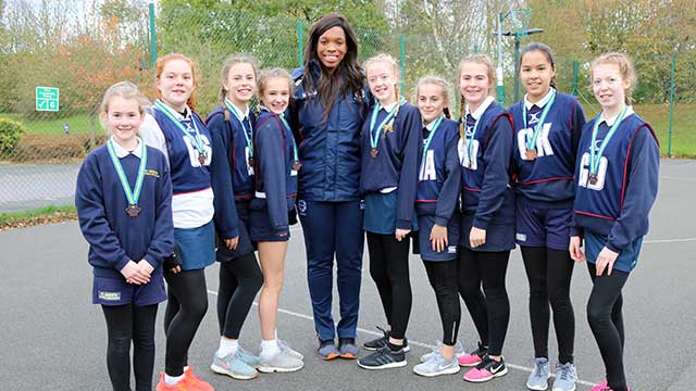 England Netball Champion Eboni Beckford-Chambers with a young netball team from St Bedes School